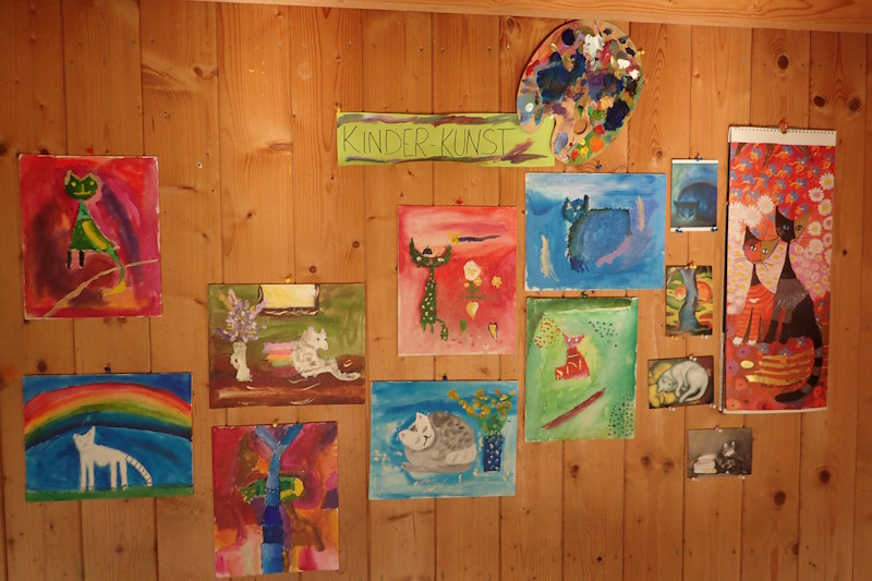 Gemälde der Kinder an der Wand. Überschrift: 'Kinder-Kunst'