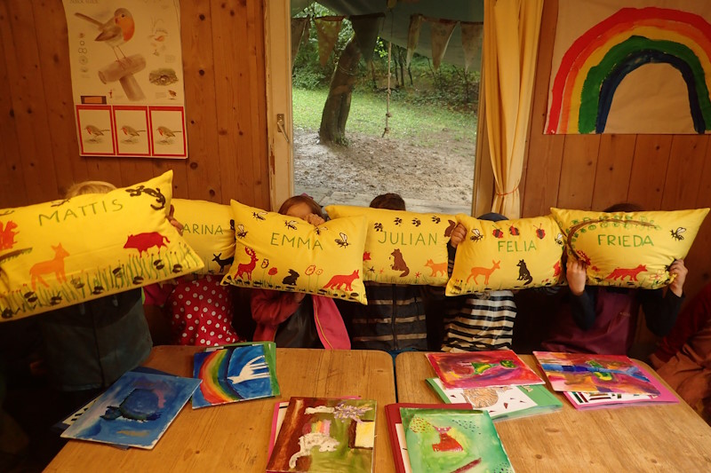 Vorschulkinder präsentieren Ihre Kissen, die ihren Namen tragen