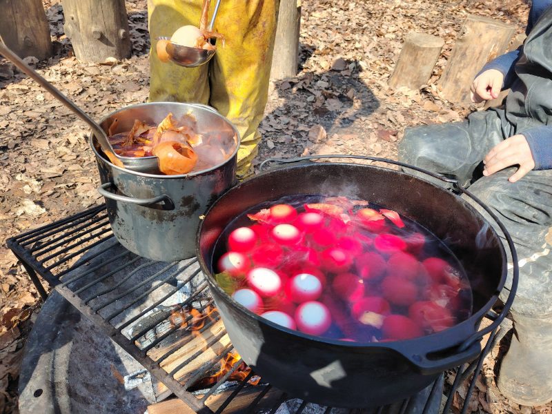 Eier färben in einem großen Topf über offenem Feuer.