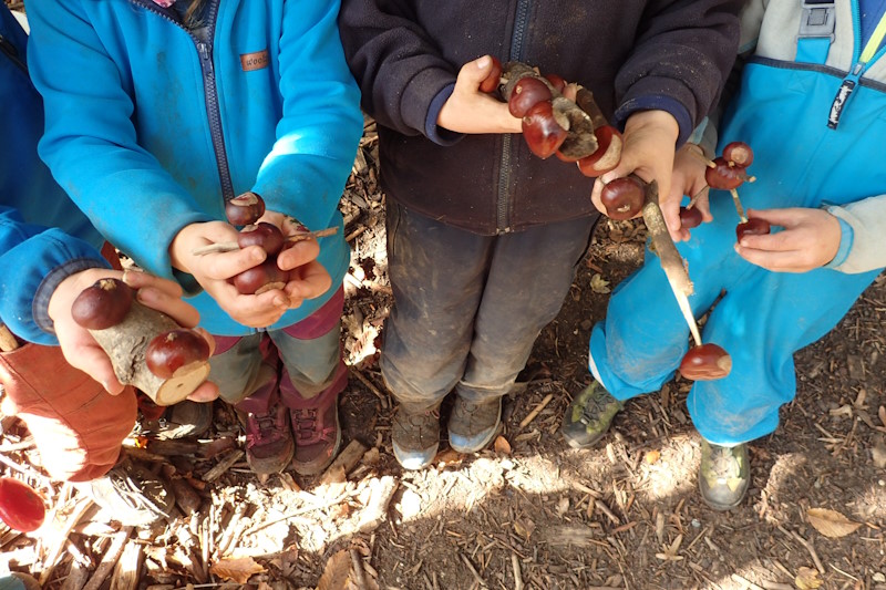 Kinder zeigen ihre selbstgebastelten Kastanienmännchen