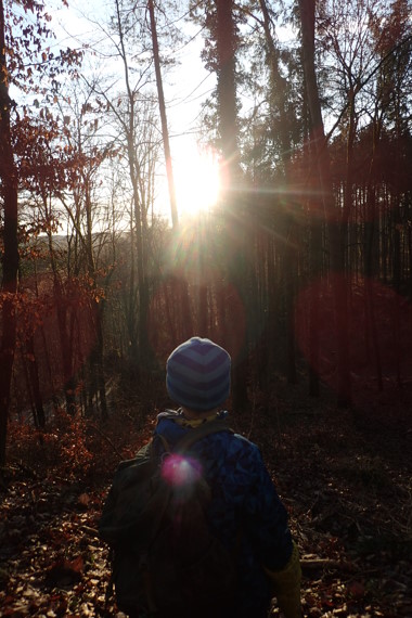 Kind im Wald bei Sonnenaufgang