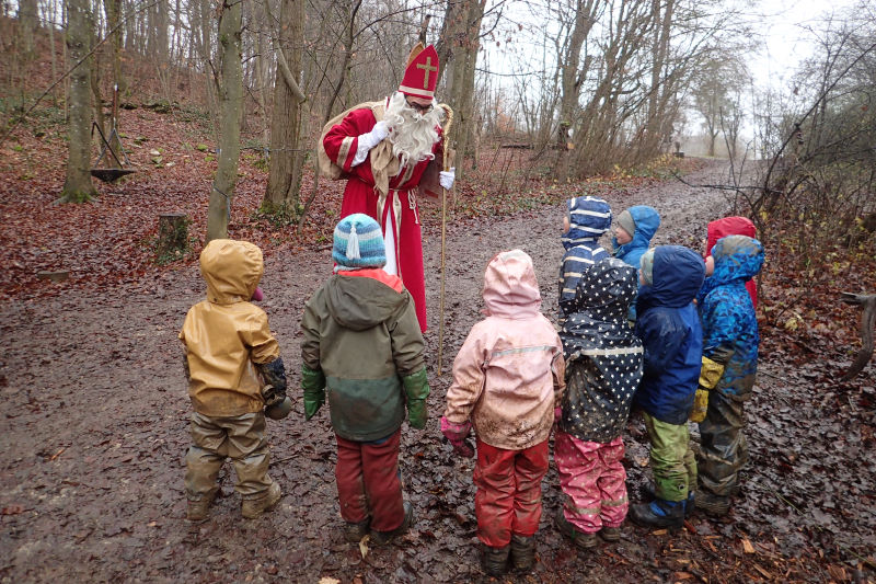 Der Nikolaus trifft die Kinder am Waldweg.